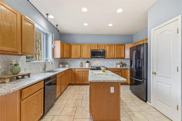 a kitchen with stainless steel appliances granite countertop a refrigerator sink and cabinets