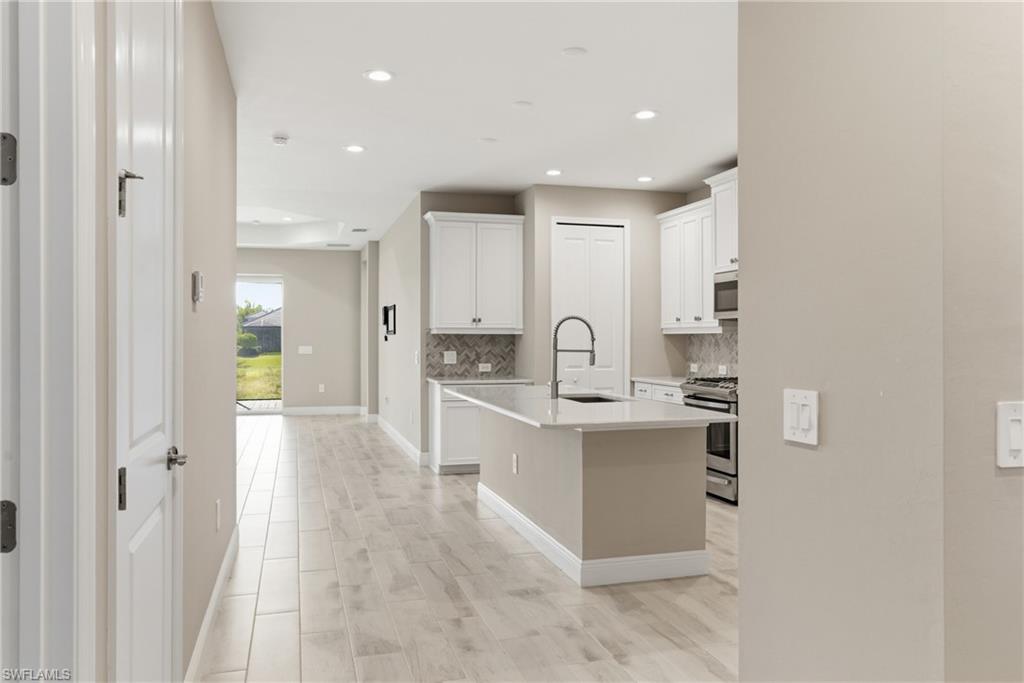 2118 Marquesa Circle Naples, FL 34112 - Photo 13 of 50 a large white kitchen with a sink and dishwasher a refrigerator with wooden floor