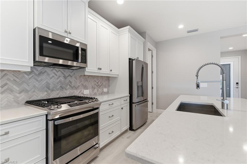2118 Marquesa Circle Naples, FL 34112 - Photo 15 of 50 a kitchen with stainless steel appliances a stove microwave and sink