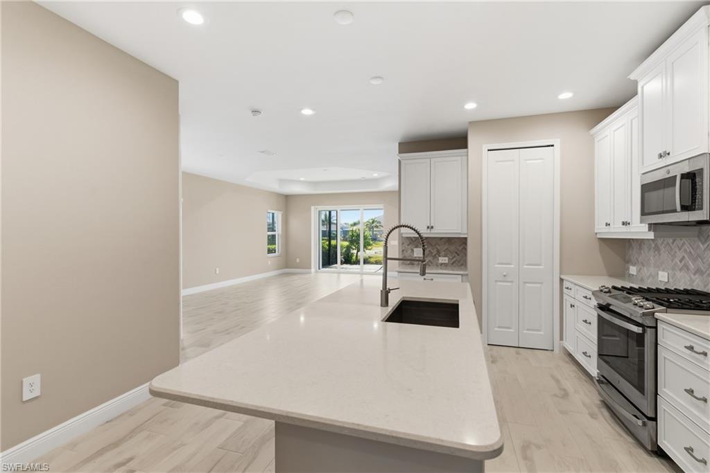 2118 Marquesa Circle Naples, FL 34112 - Photo 18 of 50 a view of a kitchen with a sink and dishwasher a stove top oven with wooden floor