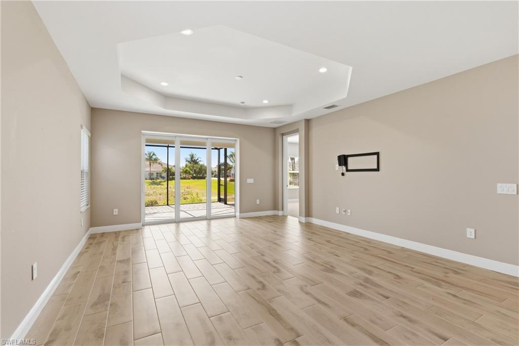 2118 Marquesa Circle Naples, FL 34112 - Photo 22 of 50 wooden floor in an empty room with a window