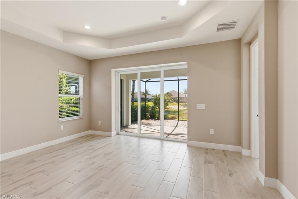 2118 Marquesa Circle Naples, FL 34112 - Photo 23 of 50 an empty room with wooden floor and windows