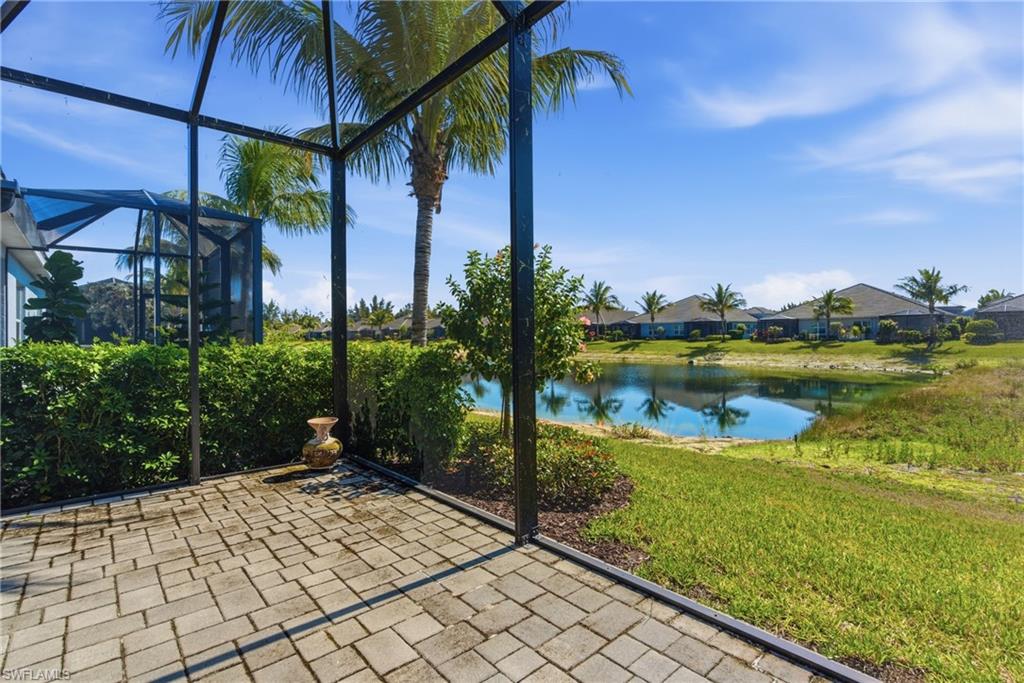 2118 Marquesa Circle Naples, FL 34112 - Photo 28 of 50 a view of a lake with lawn chairs under an umbrella