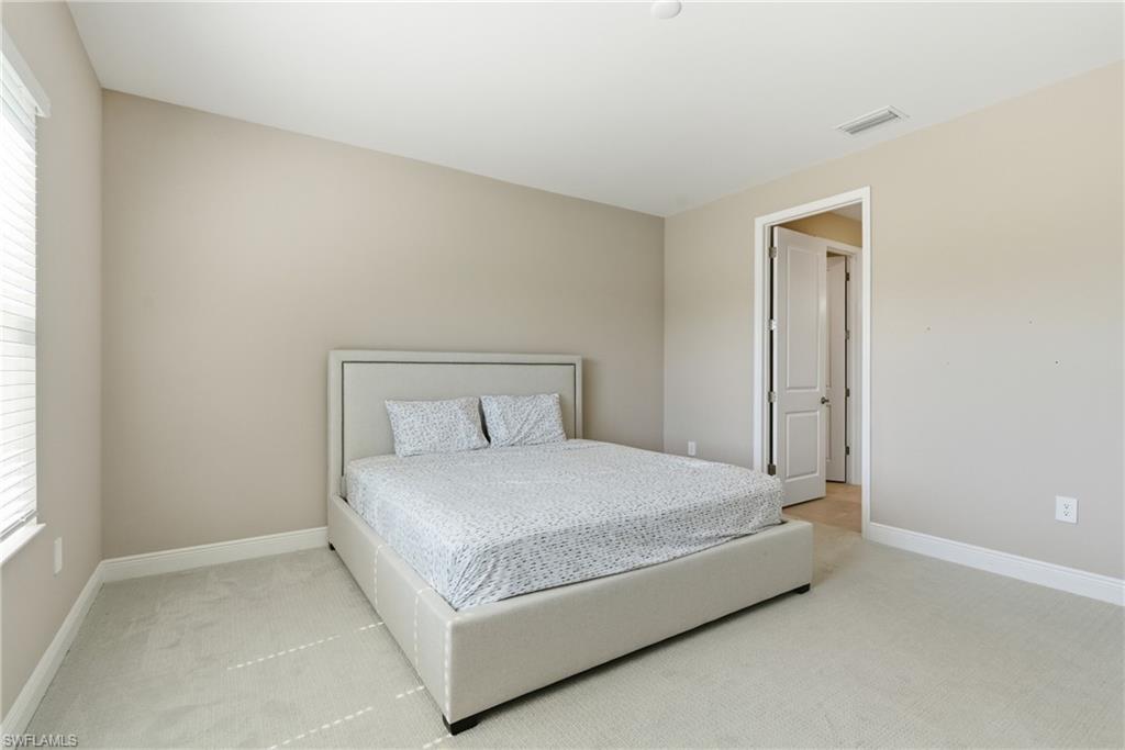 2118 Marquesa Circle Naples, FL 34112 - Photo 31 of 50 a large bed sitting in a bedroom next to a window
