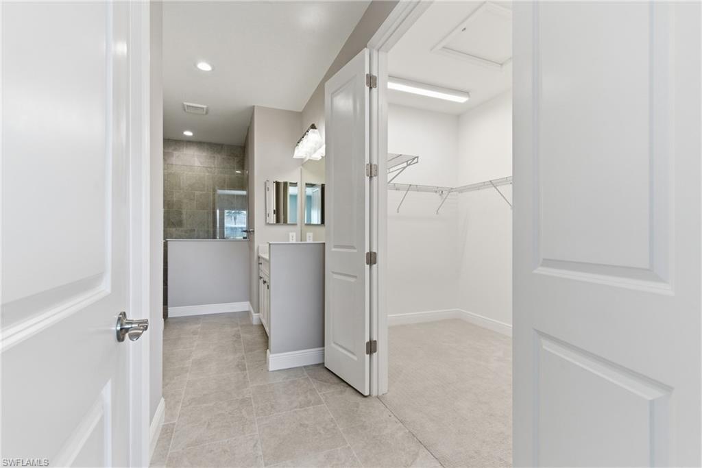 2118 Marquesa Circle Naples, FL 34112 - Photo 33 of 50 an empty room with wooden floor and mirror