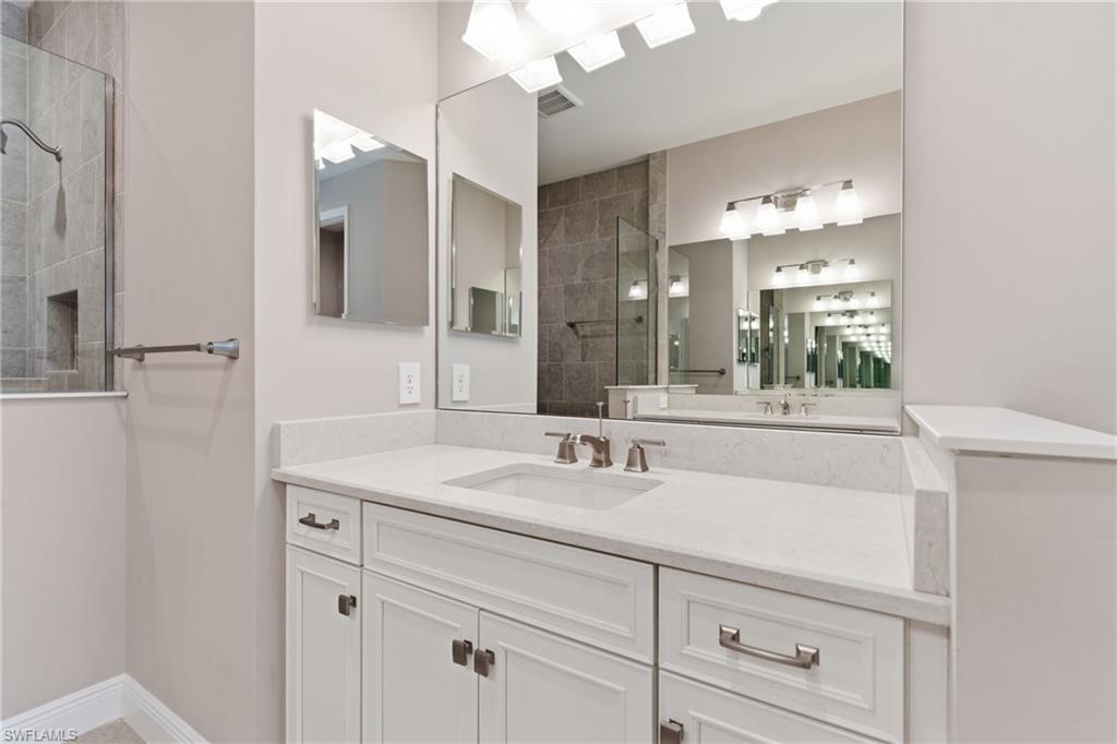 2118 Marquesa Circle Naples, FL 34112 - Photo 36 of 50 a bathroom with a sink vanity and mirror