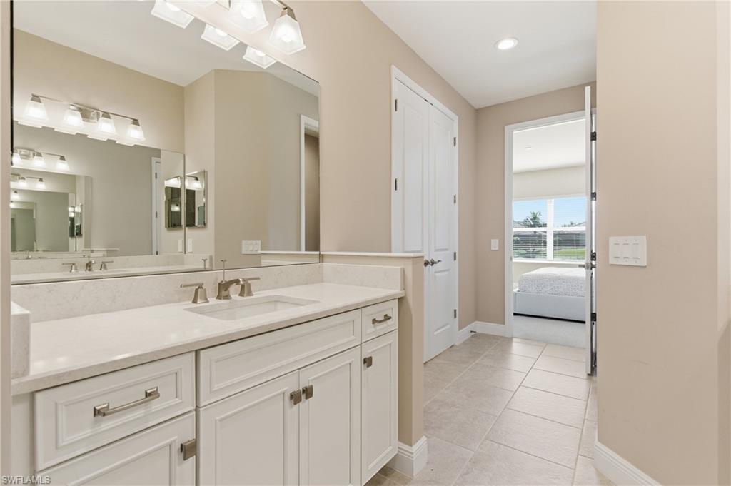 2118 Marquesa Circle Naples, FL 34112 - Photo 37 of 50 a spacious bathroom with a granite countertop sink a mirror and a