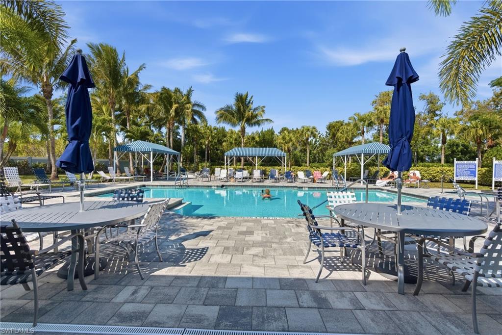 2118 Marquesa Circle Naples, FL 34112 - Photo 45 of 50 a view of a patio with table and chairs potted plants and palm tree