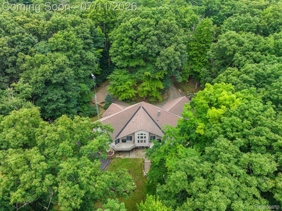 4219 Gardner Road Metamora, MI 48455 - Photo 85 of 87 Secluded property featuring a large home with a peaked roof, surrounded by mature trees