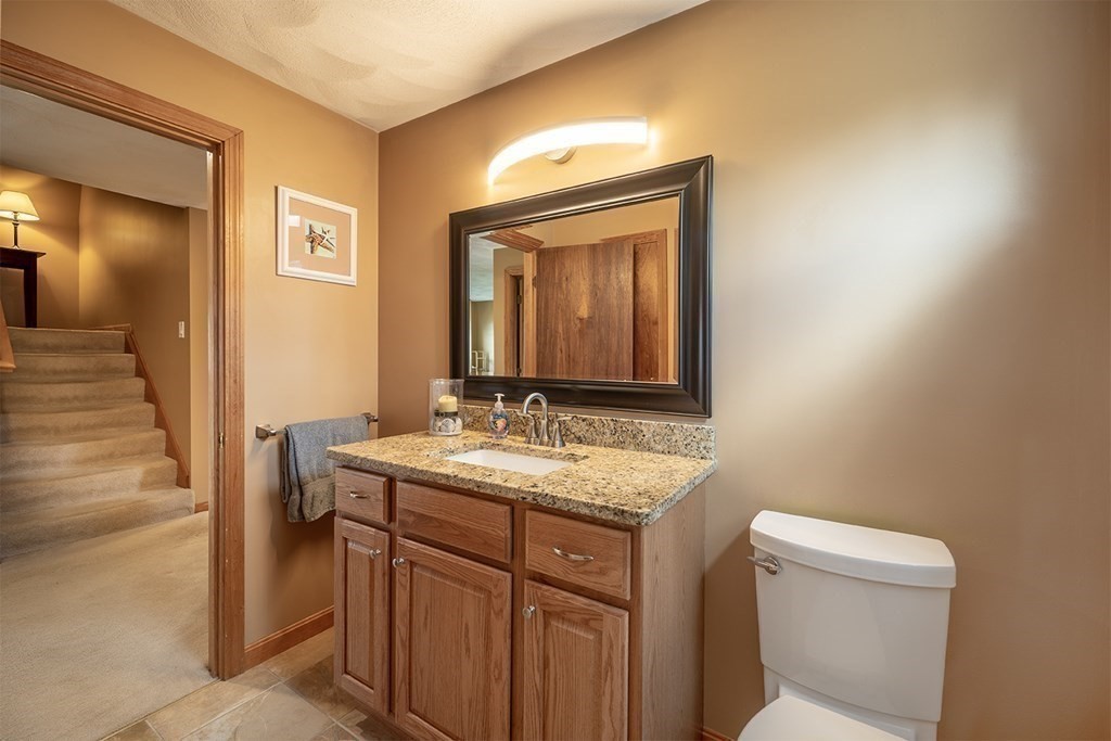 21 Swan Lane Billerica, MA 01821 - Photo 27 of 41 a bathroom with a granite countertop sink a toilet and a mirror