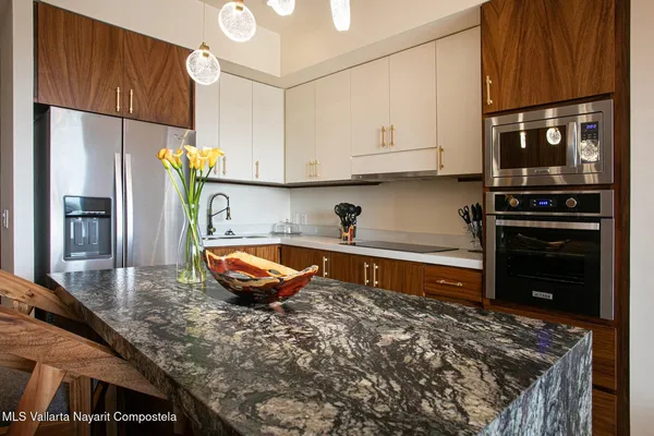 a kitchen with stainless steel appliances granite countertop a stove a sink and a microwave