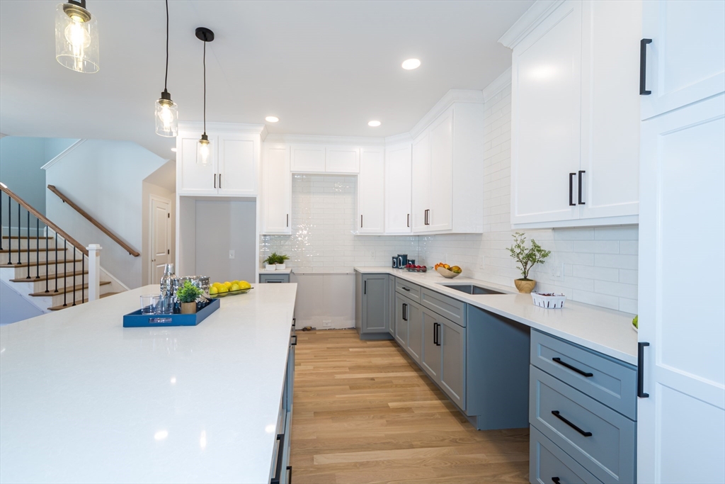 293 Bacon Street, Unit A Natick, MA 01760 - Photo 11 of 35 a kitchen with stainless steel appliances a stove a sink a center island and cabinets