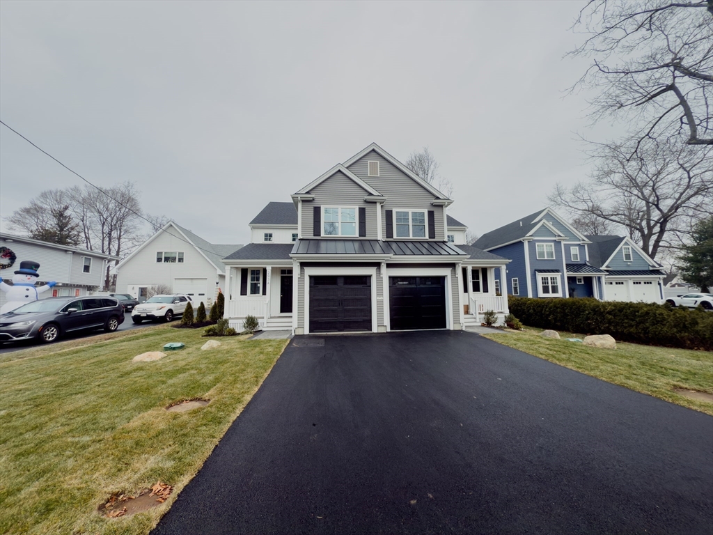 293 Bacon Street, Unit A Natick, MA 01760 - Photo 2 of 35 a front view of a house with a yard and garage