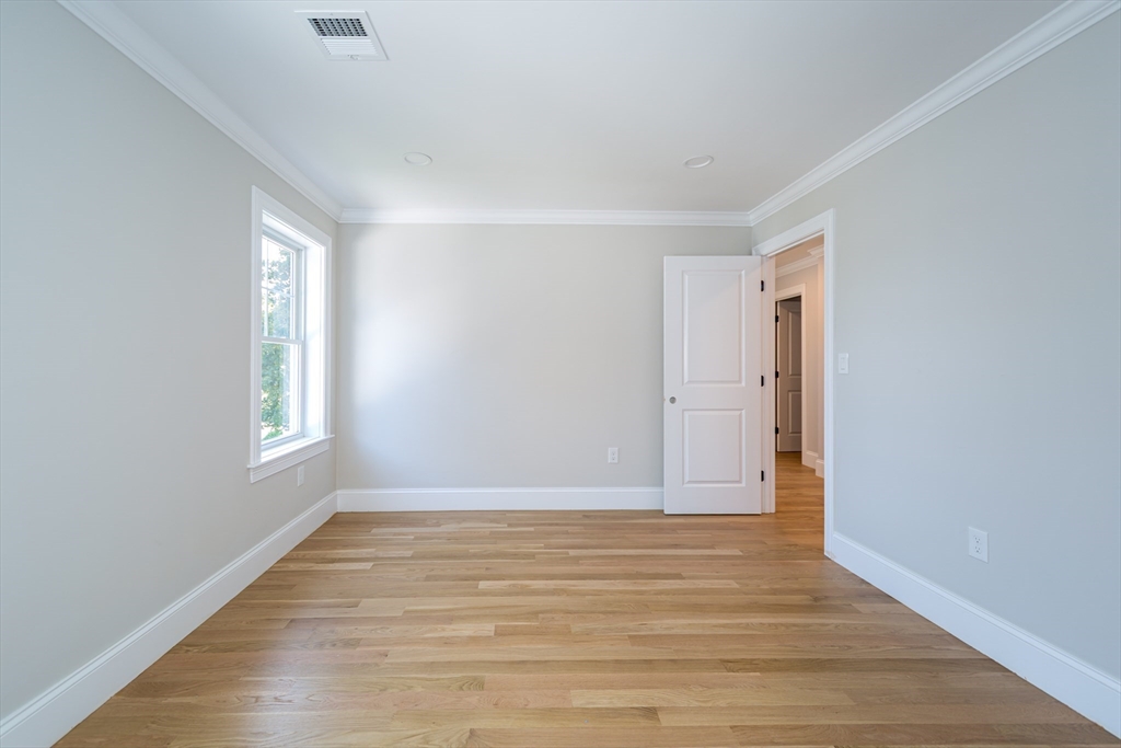 293 Bacon Street, Unit A Natick, MA 01760 - Photo 24 of 35 a view of an empty room with wooden floor and window