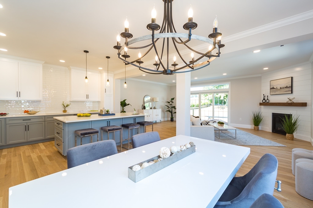 293 Bacon Street, Unit A Natick, MA 01760 - Photo 10 of 35 a large kitchen with stainless steel appliances granite countertop a sink dishwasher a dining table and chairs with wooden floor