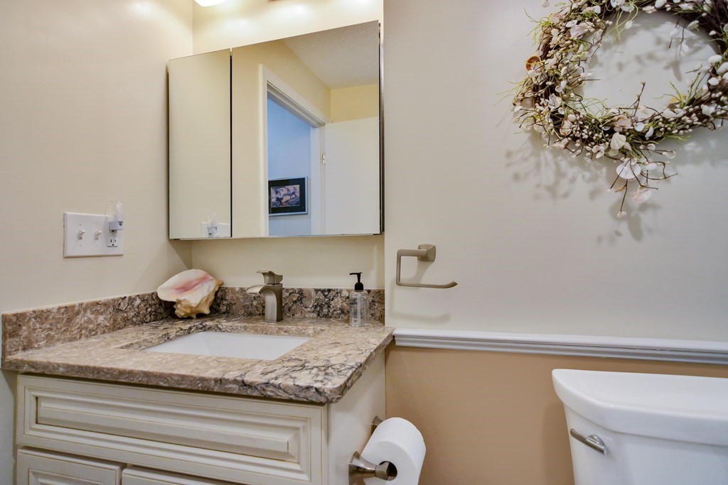 175 Willard Street, Unit 8 Lowell, MA 01850 - Photo 11 of 24 a bathroom with a granite countertop sink and a mirror