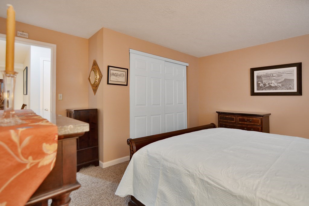 175 Willard Street, Unit 8 Lowell, MA 01850 - Photo 14 of 24 a bedroom with a bed and a table in it
