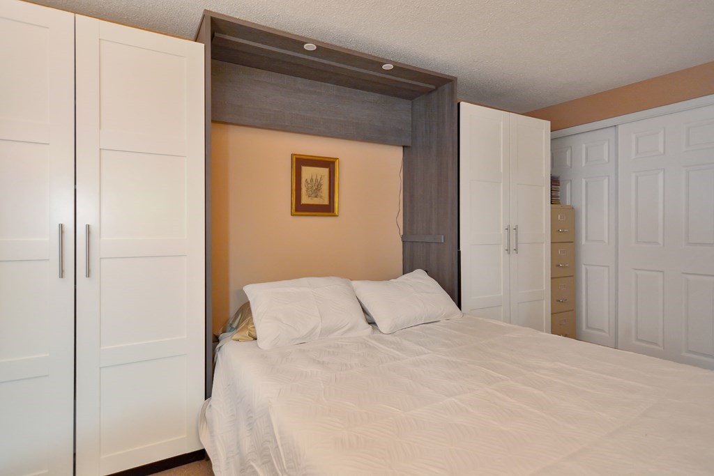 175 Willard Street, Unit 8 Lowell, MA 01850 - Photo 16 of 24 a bedroom with a bed and a mirror