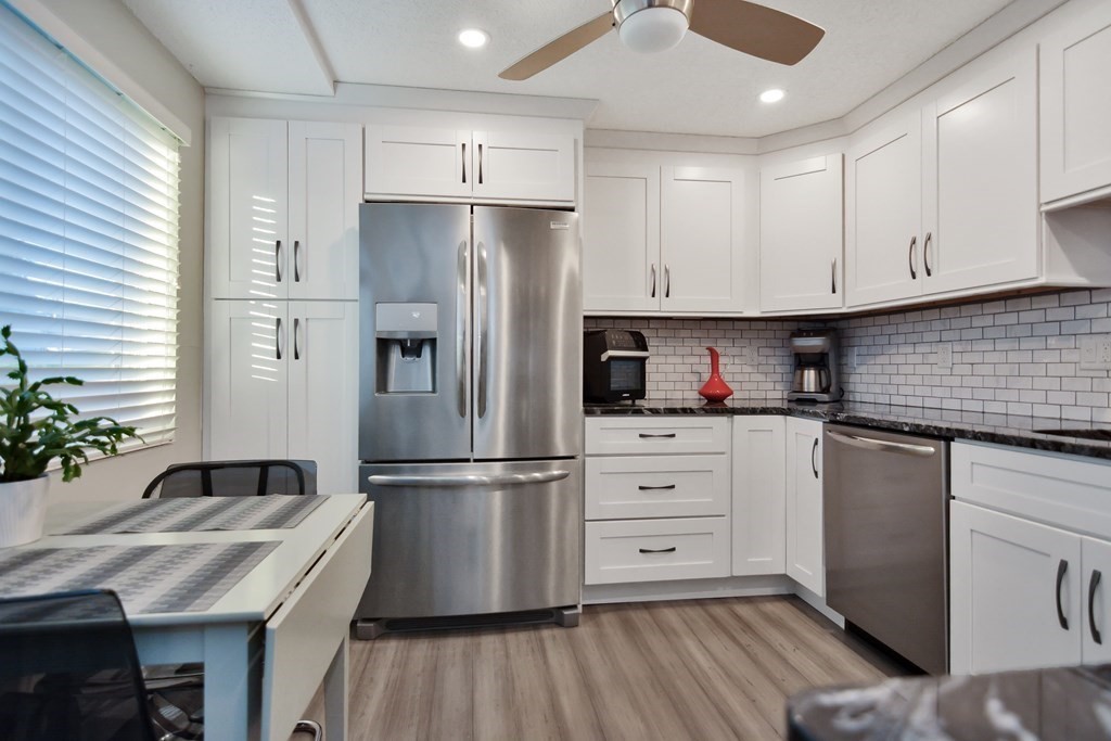 175 Willard Street, Unit 8 Lowell, MA 01850 - Photo 2 of 24 a kitchen with refrigerator a sink and cabinets