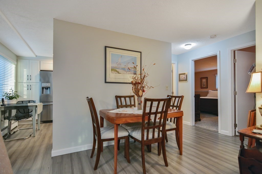 175 Willard Street, Unit 8 Lowell, MA 01850 - Photo 5 of 24 a view of a dining room with furniture and wooden floor