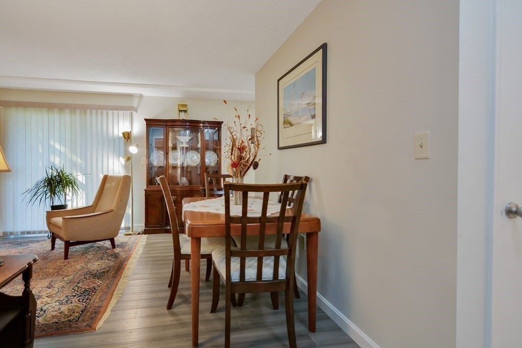 175 Willard Street, Unit 8 Lowell, MA 01850 - Photo 6 of 24 a view of a dining room with furniture and wooden floor