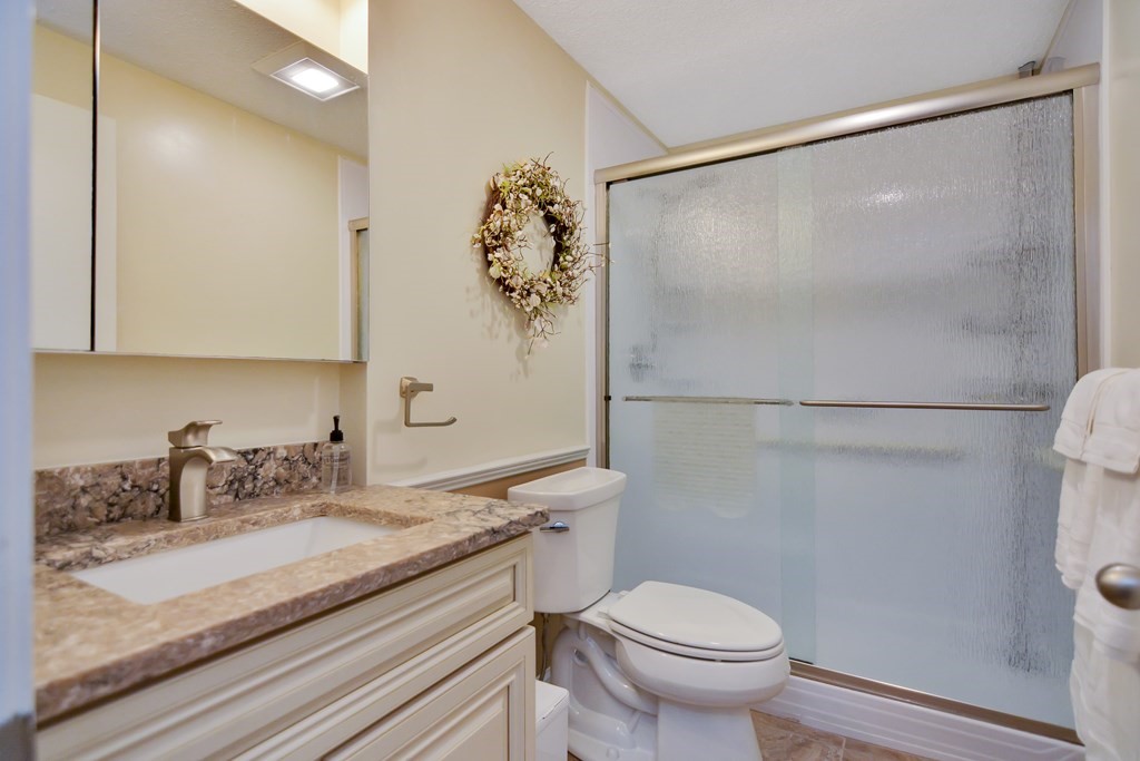 175 Willard Street, Unit 8 Lowell, MA 01850 - Photo 9 of 24 a bathroom with a granite countertop sink toilet and shower