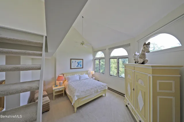 a bedroom with a bed a mirror and a window