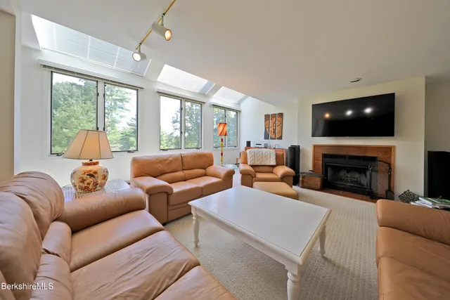 a living room with furniture a fireplace and a flat screen tv