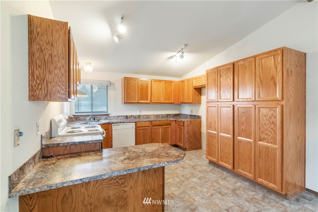 6023 188th Avenue Southwest Rochester, WA 98579 - Photo 13 of 30 a kitchen with stainless steel appliances granite countertop a sink refrigerator and cabinets