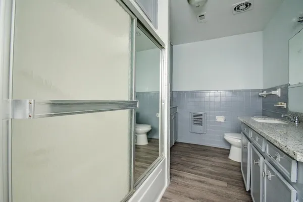 a bathroom with a granite countertop sink toilet and shower