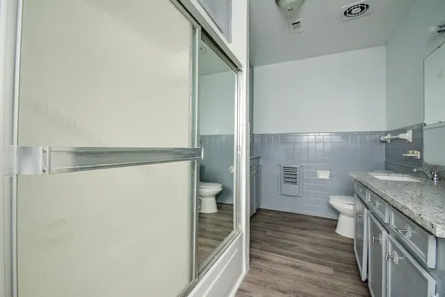 a bathroom with a granite countertop sink toilet and shower