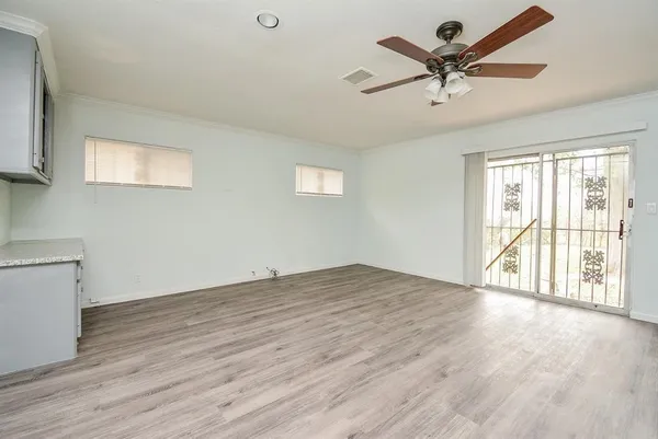 an empty room with wooden floor and windows