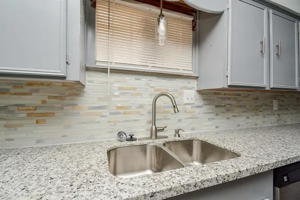 a kitchen with a sink cabinets and granite countertops