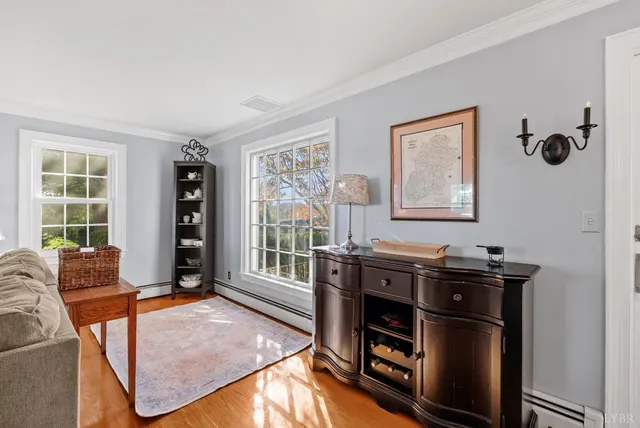 a kitchen with stainless steel appliances granite countertop a refrigerator a sink dishwasher a dining table and chairs with wooden floor