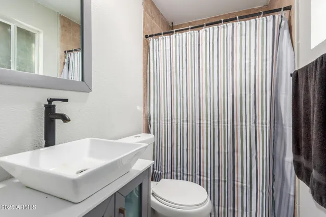 a bathroom with a white toilet sitting next to a white sink