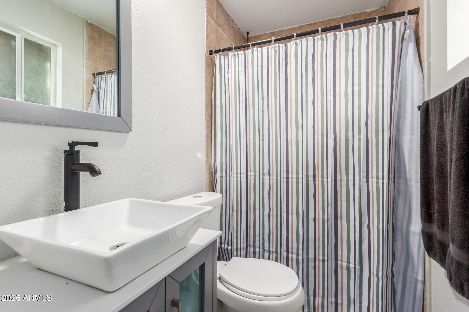 4727 West Osborn Road Phoenix, AZ 85031 - Photo 13 of 22 a bathroom with a white toilet sitting next to a white sink