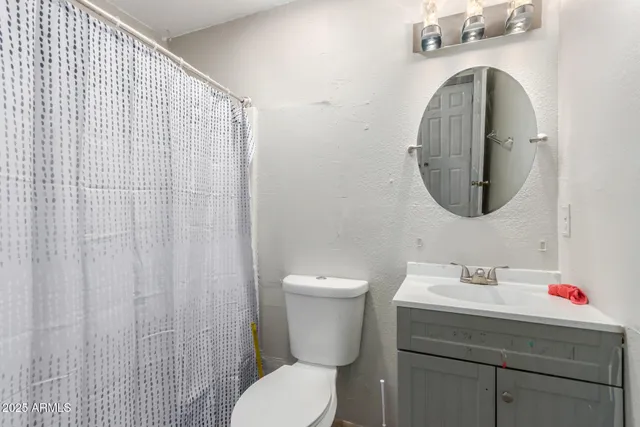 a bathroom with a sink mirror vanity and toilet