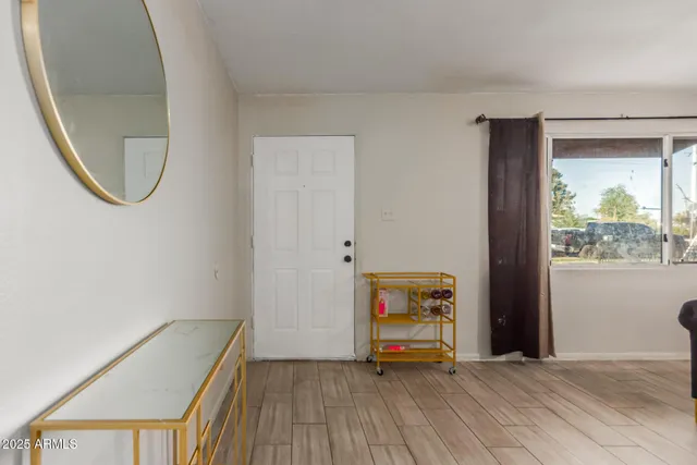 an empty room with mirror and windows