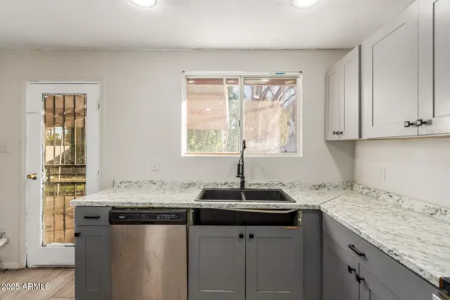a kitchen with granite countertop a sink and a window
