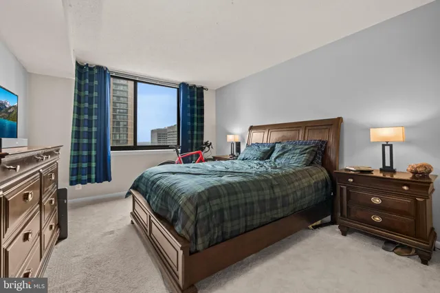 a bedroom with a bed and a dresser next to a window