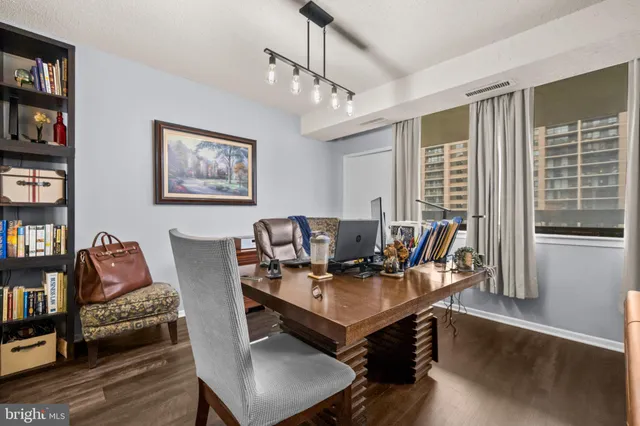 a living room with furniture a large window and wooden floor