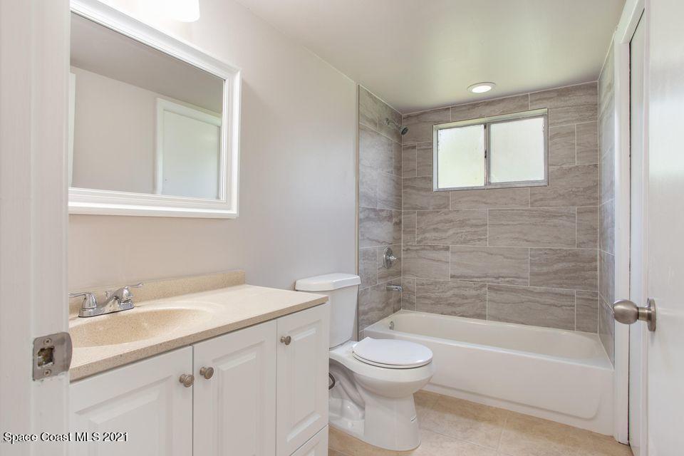 744 Ridge Club Drive, Unit 55 Melbourne, FL 32934 - Photo 12 of 15 a bathroom with a sink a toilet and shower