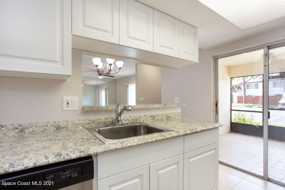 744 Ridge Club Drive, Unit 55 Melbourne, FL 32934 - Photo 13 of 15 a kitchen with granite countertop a sink and a white stove