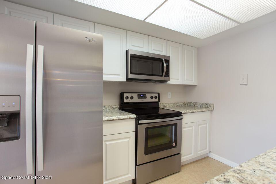 744 Ridge Club Drive, Unit 55 Melbourne, FL 32934 - Photo 14 of 15 a kitchen with microwave a stove and a refrigerator