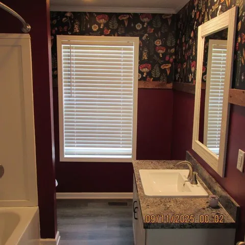 a bathroom with a granite countertop sink and a mirror