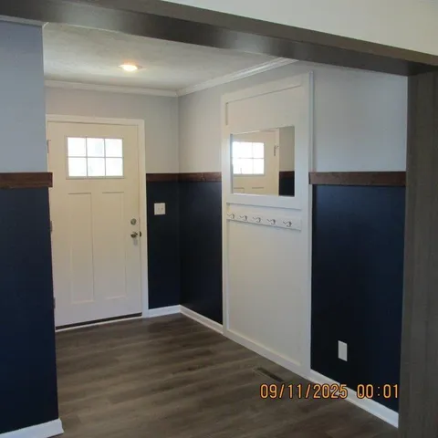 a view of empty room with window and wooden floor