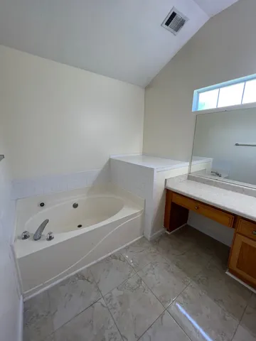 a bathroom with a tub sink and mirror