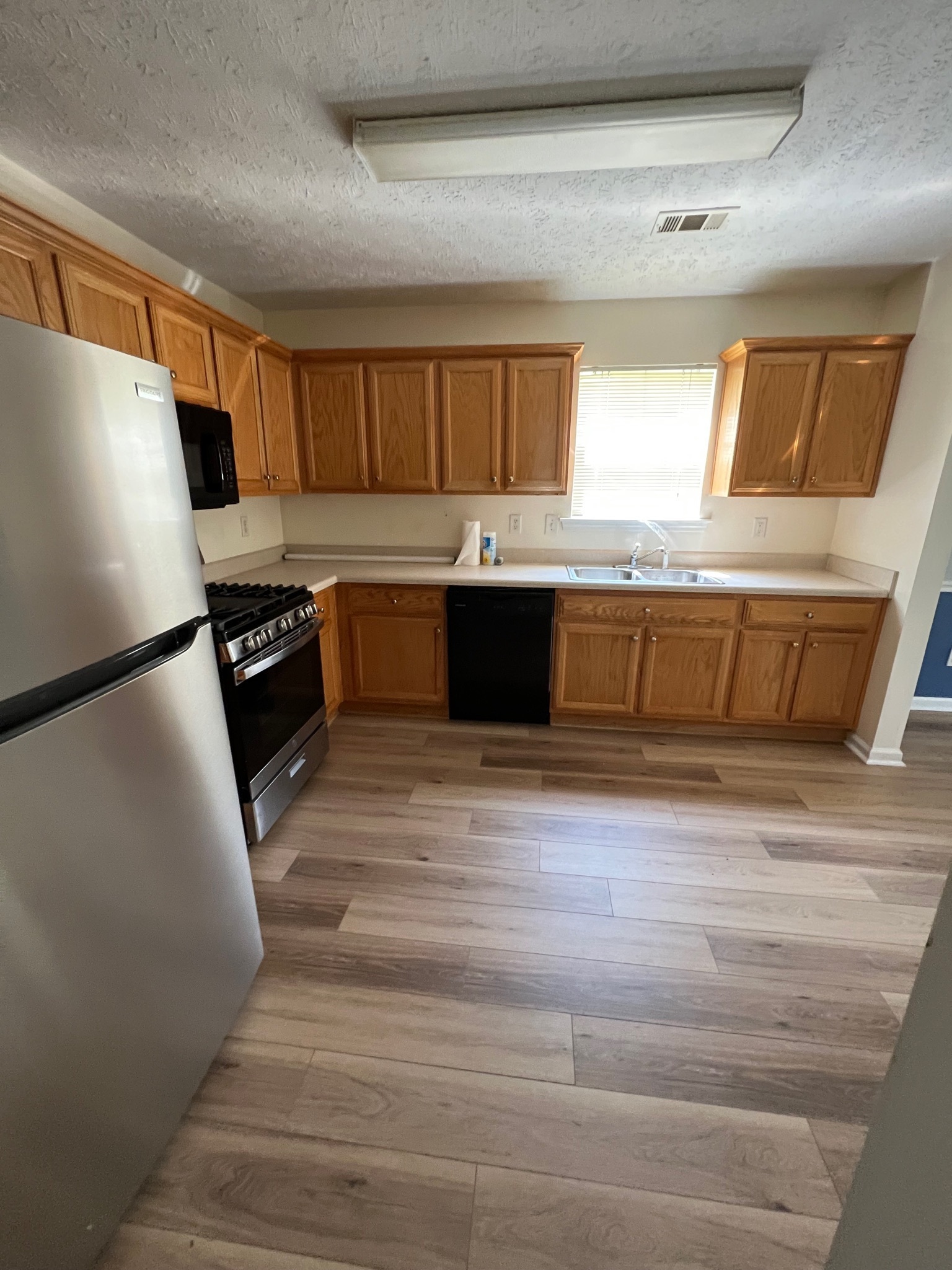 3769 Stagecoach Pass Ellenwood, GA 30294 - Photo 4 of 23 a kitchen with a refrigerator sink and wooden cabinets