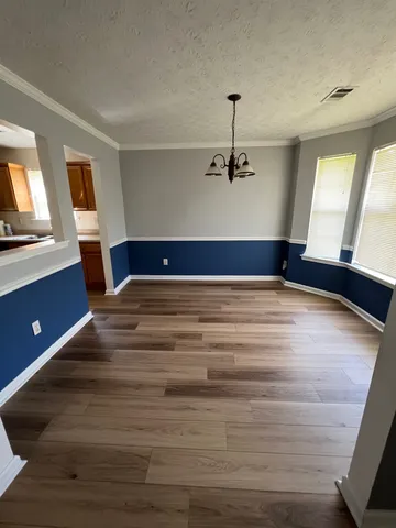 a view of a room with a ceiling fan and wooden floor