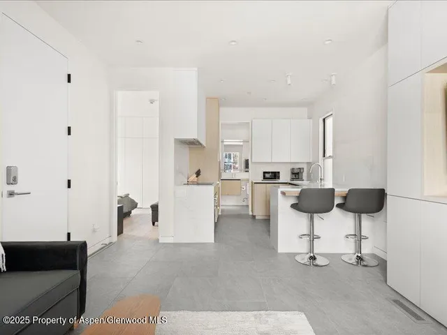 a kitchen with stainless steel appliances kitchen island refrigerator sink and white cabinets
